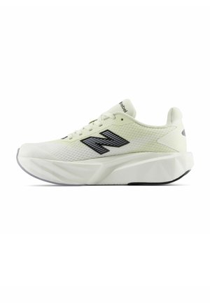 Lyse beige sportsko med tyk hvid sål, sort striped New Balance logo på siden og snørelukning.