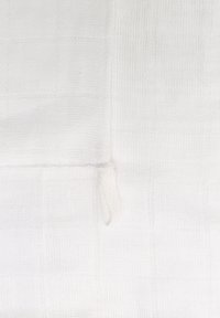 White woven textile featuring a grid pattern with a soft texture, finished with a loose thread detail on one edge.