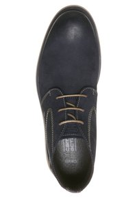 Chaussure habillée noire en cuir à lacets, avec des lacets marron clair et des coutures blanches, vue de dessus sur un fond blanc.