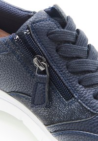 Sneakers blu navy con tessuto a trama, dotati di lacci e chiusura con zip. Presentano dettagli scintillanti sui lati e una suola in gomma bianca.