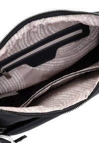 Interno di una borsa in tessuto scuro con una tasca con zip e due scomparti, rivestita con un motivo che mostra testo bianco su uno sfondo chiaro.