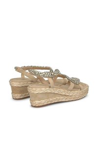 Infradito con zeppa in juta intrecciata spessa, di colore beige, con un design di cinturini decorati con strass e una parte superiore in morbido camoscio.