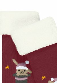 Rote gestrickte Socken mit einem weißen, flauschigen Bund. Sie zeigen ein verspieltes Motiv eines Hasen im Weihnachtsmann-Hut, verziert mit kleinen gelben und weißen Details.