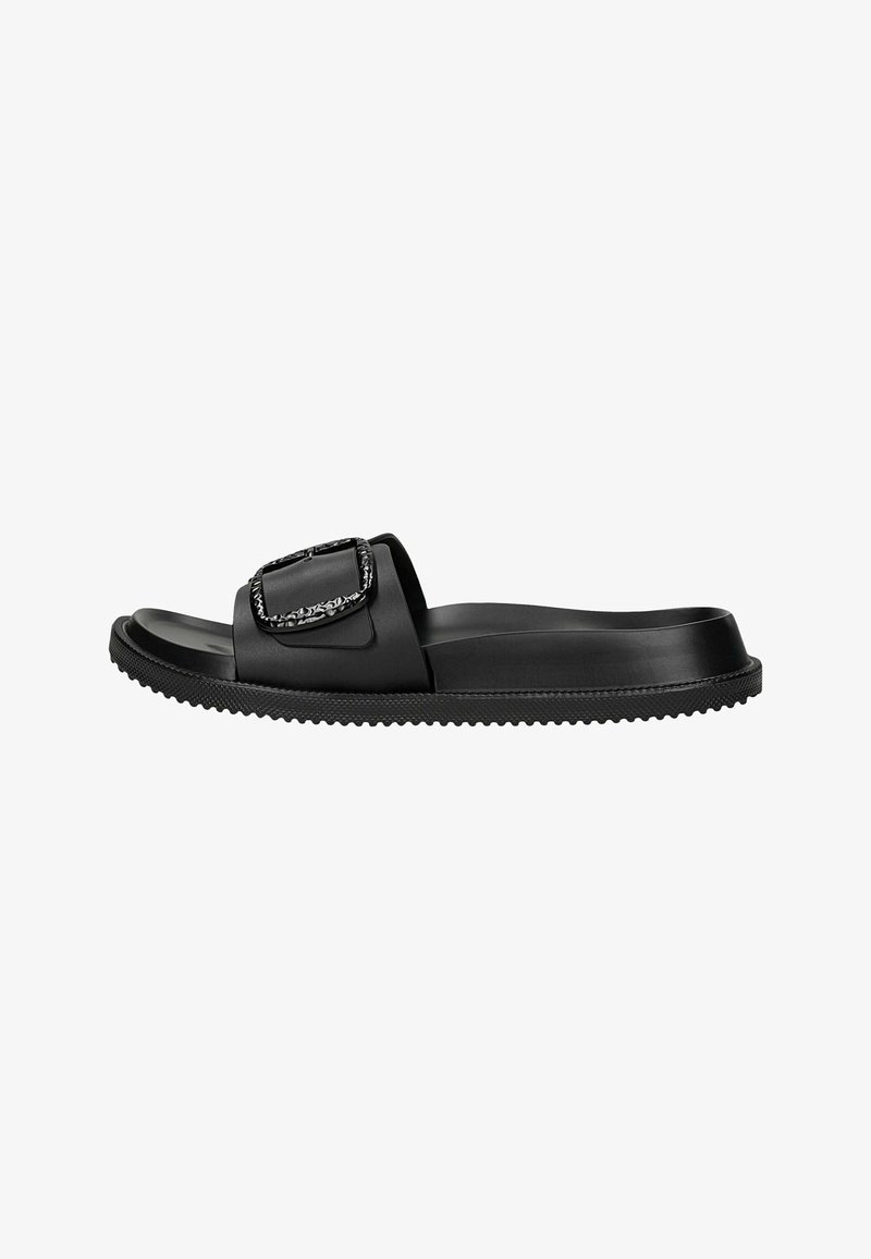 Sandale slide noire avec semelle texturée et large bride avec une grande boucle décorative sur le dessus.