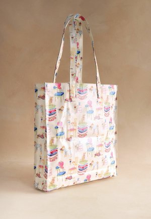 Kremowa torba na ramię z długimi uchwytami, ozdobiona kolorowymi nadrukami psów, stosami poduszek i małymi meblami.