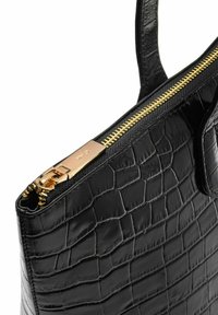 Czarna torba tote z tłoczonej skóry krokodyla z złotym zamkiem błyskawicznym i gładką fakturą, z podwójnymi uchwytami i smukłym profilem.
