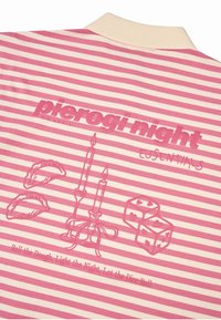 Prúžkovaná ružovo-krémová látka obsahuje text "noc pierogov", sviečky, pierogi a grafiku kociek. Jednoduchý, hravý dizajn s jemnou textúrou.