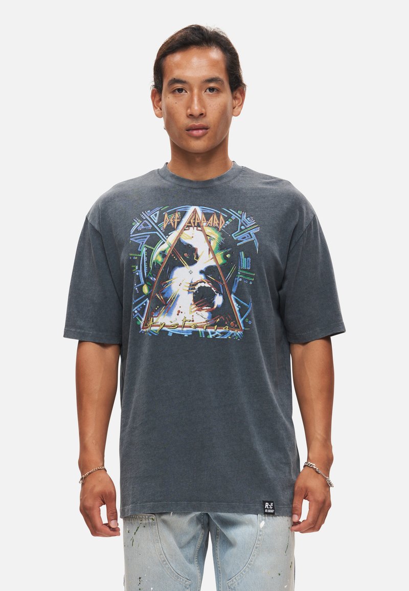 Grafisk t-shirt i mörkgrå bomull med en färgglad tryck av en hund inom en triangel, med djärva detaljer och avslappnad passform.