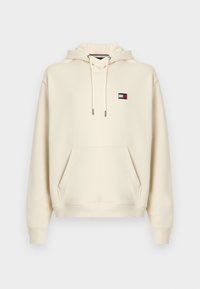 Φούτερ με κουκούλα μπεζ χρώματος από μαλακό ύφασμα, με τσεπάκι μπροστά, κουκούλα με κορδόνι και μικρό κεντητό λογότυπο σε μπλε, κόκκινο και άσπρο χρώμα.