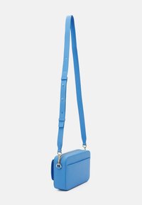 Modrá kožená kabelka přes rameno obdélníkového tvaru, nastavitelný popruh, zlatý zip a přední kapsa pro další úložný prostor.