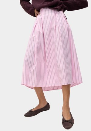 Midi nederdel med pink og hvide striber og plisseringer, lavet af et let stof. Brune flade sko med sløjfedetalje fuldender looket.