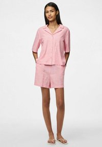 Rožinė ir balta dryžuota trumpomis rankovėmis marškinėlių palaidinė su mygtukais ir atitinkamos šortai, pagaminti iš lengvos medžiagos, su apykakle ir laisvu siluetu.