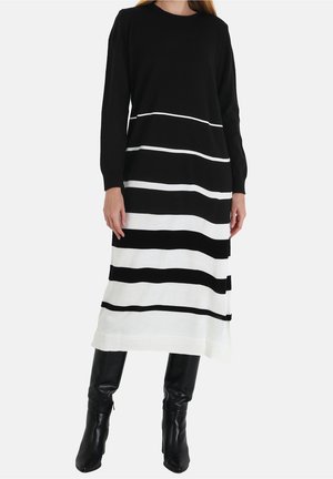Sort-hvid stribet strikkjole med lange ærmer og rund halsudskæring, som har vandrette striber og en ribbet kant.