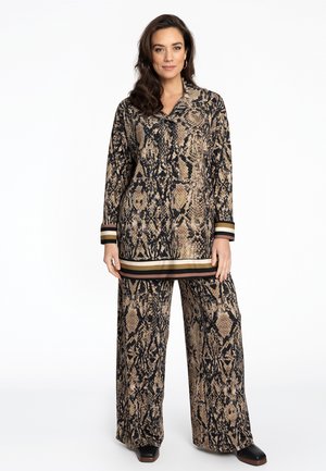 Langarm-Bluse mit Schlangenprint und weiten Hosen in Schwarz, Beige und Braun. Mit Streifen an den Bündchen und dem Saum. Weicher, strukturierten Stoff.