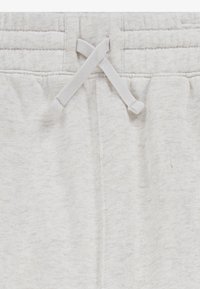 Svetlosivé tepláky majú elastický pás so šnúrkou, mäkkú textúru a dvojité švy pozdĺž pásu pre zvýšenú stabilitu.