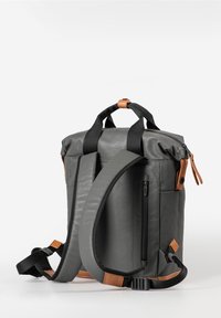 Grijze, waterdichte rugzak met dubbele draaghandgrepen, verstelbare schouderbanden, met leren accenten in bruin en een zijvak met rits. Voorzien van een oprolbare sluiting.