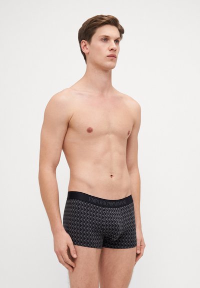 Black boxer briefs with a geometric pattern, elastic waistband featuring "Emporio Armani" branding, made from a smooth fabric.