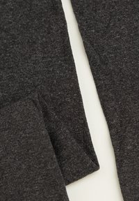 Tissu noir texturé, présentant un matériau doux et élastique avec une surface lisse. Le tissu affiche des motifs subtils et des nuances variées de gris foncé.