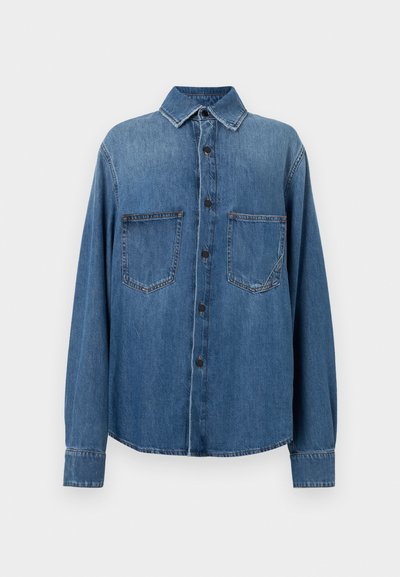 Keskmise sinise tooni denimist särk klassikalise kraega, ees nööpide sulgemisega, kahe rinnataskuga ja pika varruku ning nööpide mansettidega.