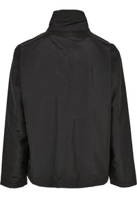 Chaqueta ligera negra con un cuello alto, mangas largas y una textura suave; presenta un diseño sencillo sin herrajes ni acentos visibles.