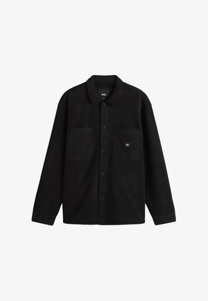 Chaqueta de polar negra con cuello tipo camisero, cierre de botones a presión en la parte delantera, dos bolsillos en el pecho y una pequeña etiqueta de la marca en el bolsillo izquierdo.