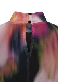 Kleurrijke, patroonrijke meshstof met een hoge kraag, voorzien van twee zwarte knopen aan de achterkant en een open ontwerp. Voornamelijk roze en zwart.