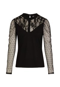 Top nero con maniche lunghe in tessuto trasparente caratterizzate da pois. Il corpetto presenta un sovrapposto di pizzo a forma di V con bottoni decorativi sul collo.