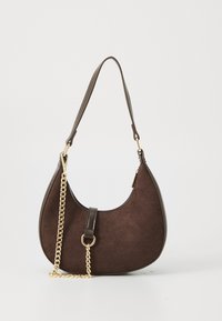 Tummanruskea kuun muotoinen mokkahandbag, jossa on nahkareunat, lyhyt olkahihna ja koristeellinen kultaketju edessä.