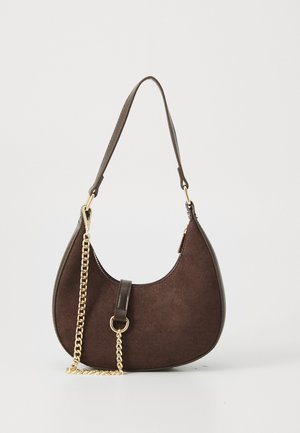 Sac à main en suède marron foncé en forme de croissant avec des finitions en cuir, une courte bandoulière et un détail de chaîne dorée décorative pendent à l'avant.