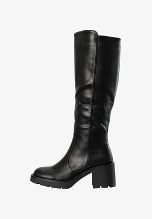 Bota de cuero negra hasta la rodilla con tacón grueso y suela resistente, caña lisa con costuras mínimas, perfil ergido.
