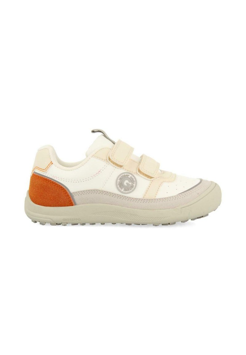 Zapatilla blanca con acentos en beige y naranja, que presenta dos correas de Velcro, puntera redondeada, suela de goma texturizada y un detalle de logo circular.