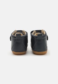 Chaussures noires en cuir avec un intérieur doux, présentant un bout arrondi, des détails cousus et une semelle en caoutchouc souple pour le confort.