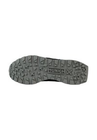 Suela de zapato negra con un patrón de textura prominente, que presenta picos y formas angulares. Logo "MUNICH" grabado en la entresuela.