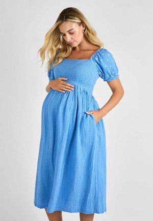 Blue, knee-length dress with a square neckline, puff sleeves, and side pockets. Made of textured fabric with subtle white accents.