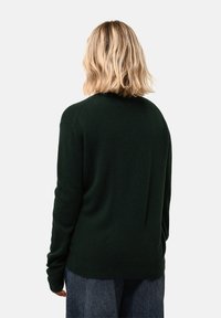 Tmavě zelený svetr vyrobený z měkkého materiálu, s kulatým výstřihem a ribbovanými manžetami. Design je jednoduchý, s volným střihem a bez vzorů.