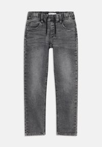 Jean en denim gris avec une taille élastique, un cordon de serrage, un design à cinq poches et une jambe fuselée. Présente une décoloration et des coutures visibles.