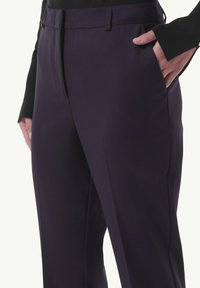 Slim-fit, ciemnofioletowe spodnie wykonane z gładkiego materiału, z płaskim przodem, bocznymi kieszeniami i dopasowanym pasem.