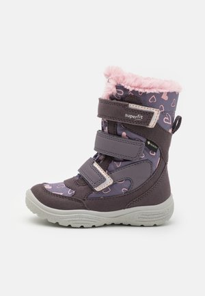 Violetti talvisaapas, jossa on sydänkuvioita, vaaleanpunainen tekoturkistrimmi, kaksi tarranauhaa ja teksturoitu harmaa kumipohja. Vedenpitävä malli.