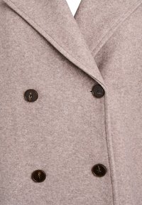 Double-breasted coat in light beige wool blend with a soft texture. Features dark round buttons and a notched lapel collar.