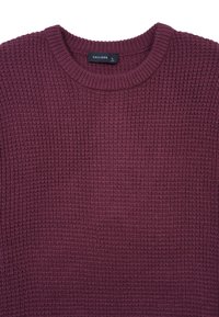 Strickpullover in Burgunderrot, mit einem strukturierten Muster, rundem geripptem Ausschnitt und Etikett mit Größeninformation. Weicher Stoff.