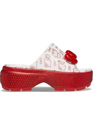 Mule blanche à plateforme avec semelle rouge pailletée, ornée de visages rouges de Hello Kitty et d'un grand nœud rouge sur le dessus.