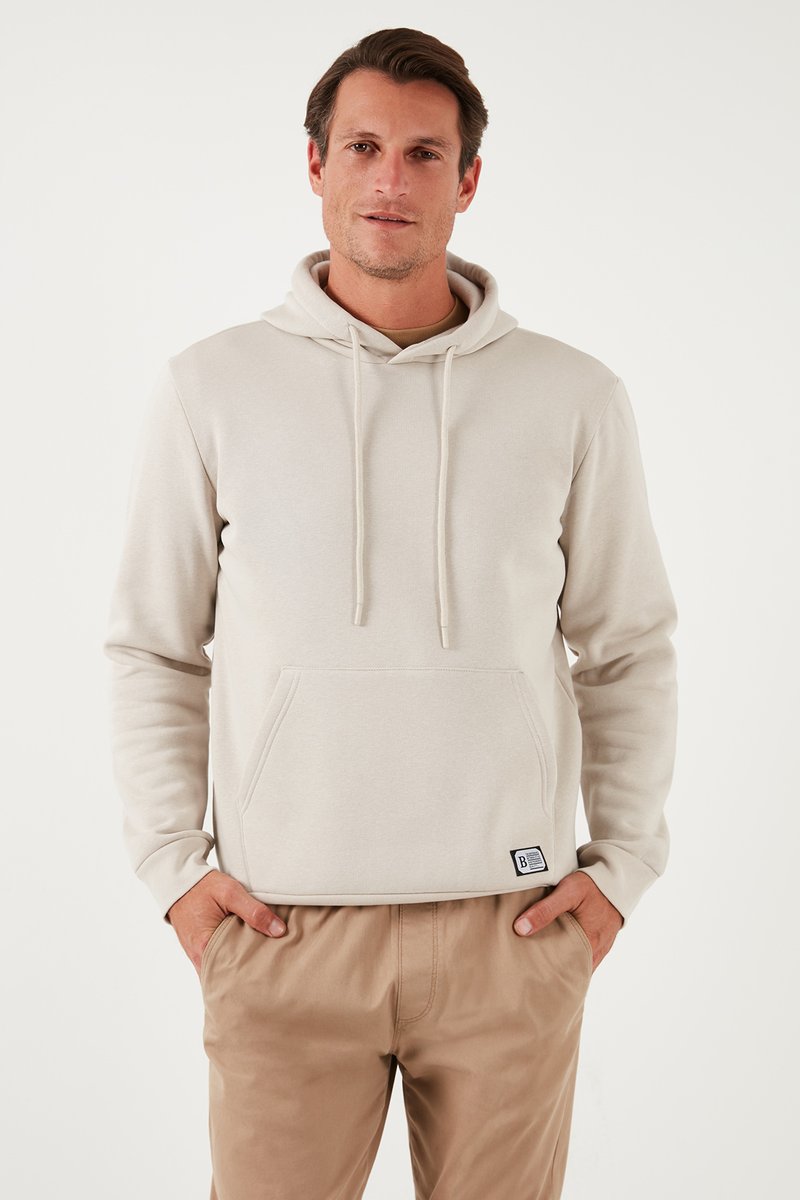 Felpa beige con tasca frontale, coulisse regolabile e una piccola etichetta con logo in fondo. Tessuto morbido e di peso medio.