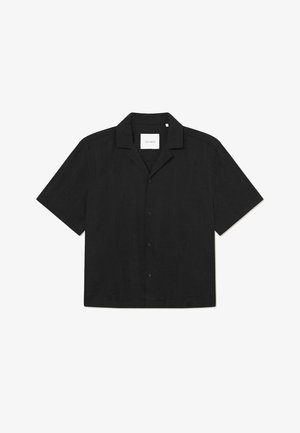 Black short-sleeve shirt with a button closure, flat collar, smooth texture, and subtle pattern on fabric, labeled "LES DEUX" inside.