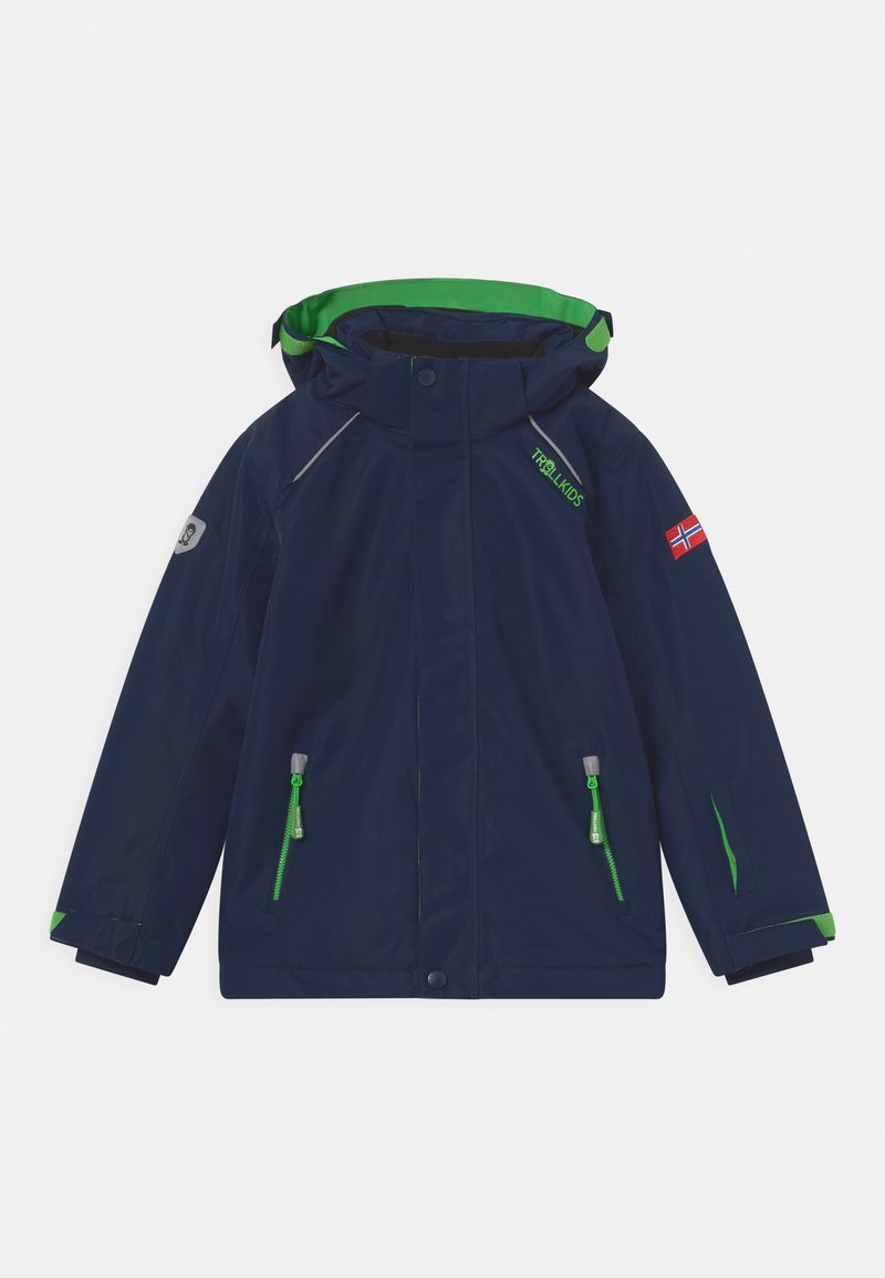 Casaco de chuva infantil azul-marinho com forro verde no capuz, detalhes reflexivos e bolsos verdes com fecho. Inclui um emblema com uma bandeira.