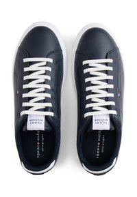 Navy blue leather sneakers featuring white laces, low profile, and contrasting white sole. Includes logo on the tongue and subtle accents.