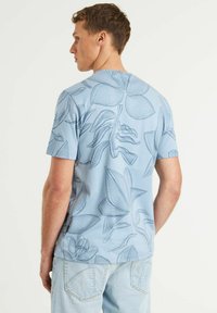 Šviesiai mėlynas trumpomis rankovėmis marškinėliai su gėlių linijiniu piešiniu. Lygi tekstūra, apvalus iškirpimas ir laisvas kirpimas.