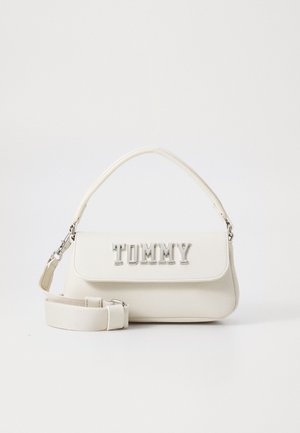 Bolso blanco con asa superior y correa ajustable. Presenta un cierre de solapa y un logo en relieve plateado "TOMMY" en la parte frontal. Textura suave.