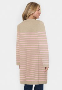 Beige kardar med rosa och vita horisontella ränder. Ribbad textur, långa ärmar och en hög-låg nederkant. Lätt och mjukt material.