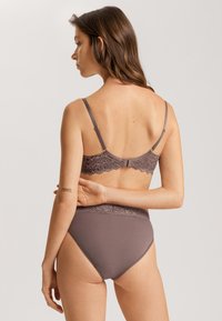 Bruin beha met kantafwerking, verstelbare bandjes en bijpassende high-waisted slip, met een gladde textuur en naadloos ontwerp.