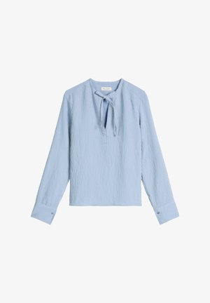 Blouse à manches longues à rayures verticales bleu clair et blanches avec une encolure en forme de goutte et un fin lien au col.